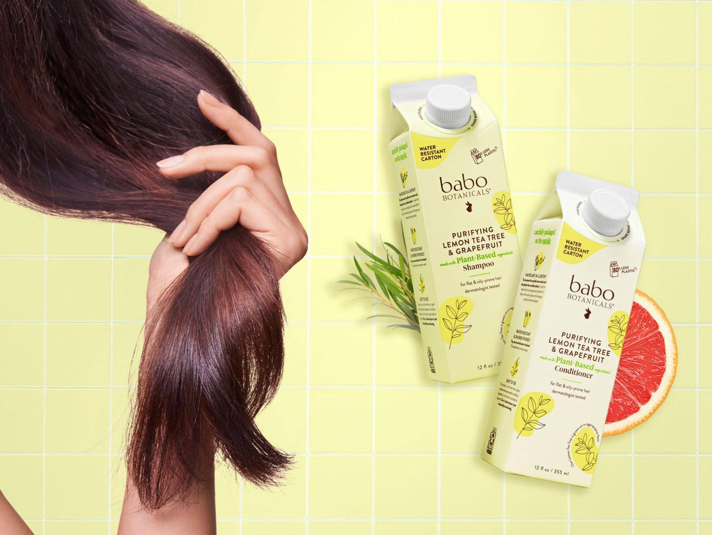 Babo Botanicals Purifying Lemon Tea Tree & Grapefruit Shampoo & conditioner- Woman holding her hair next to shampoo